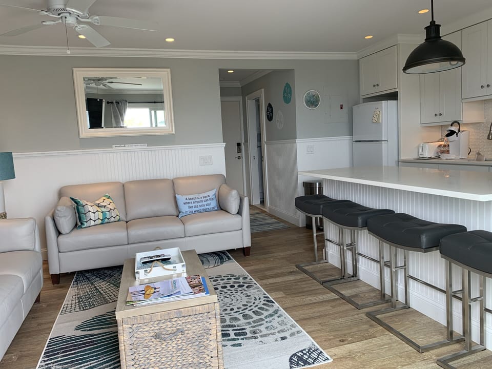 View of living area, kitchen & entrance from sliders.