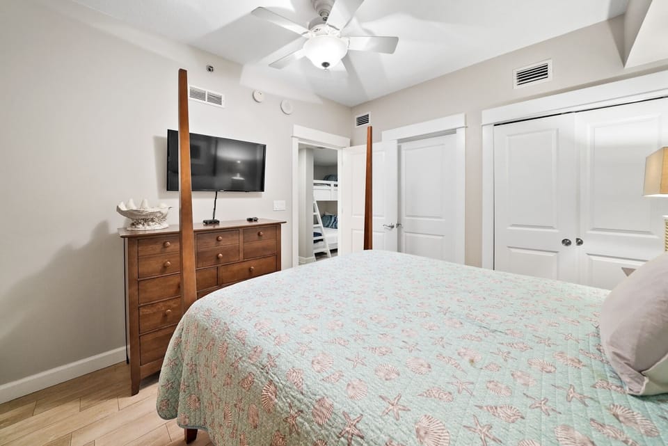 Drift off in your serene bedroom with elegant four-poster bed, ceiling fan for comfort, and entertainment center for relaxing evenings.