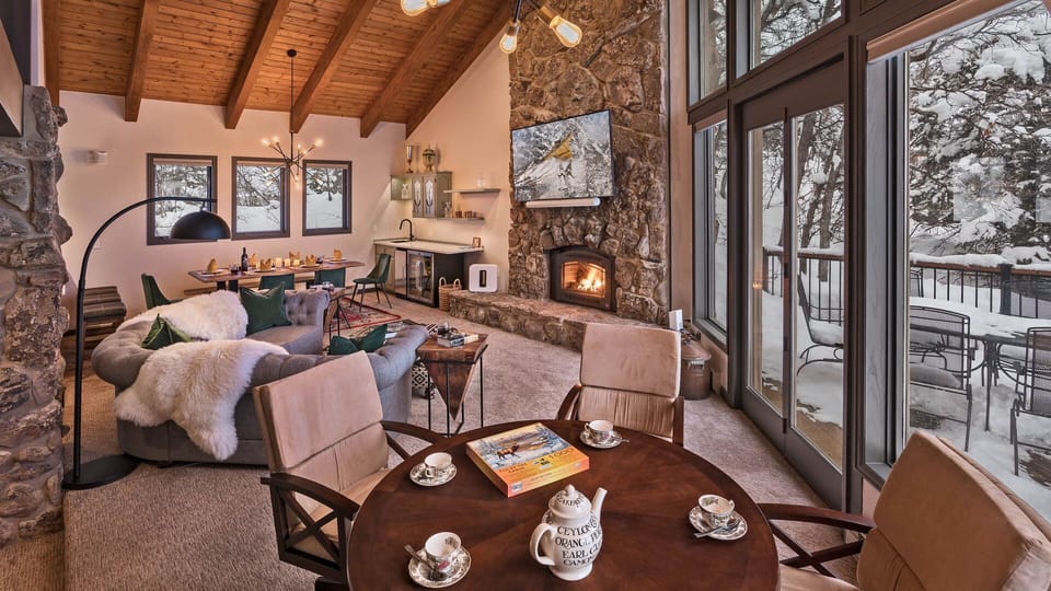 Great Room, Main Level - Round table set beside stone fireplace and glass doors