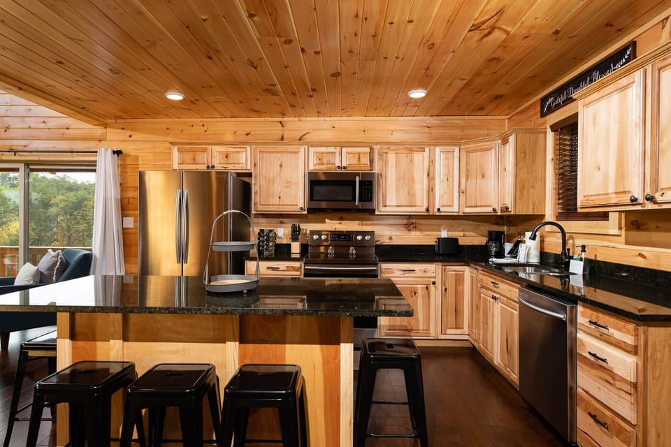 Modern kitchen with eat-in island, stainless appliances, and cookware provided.