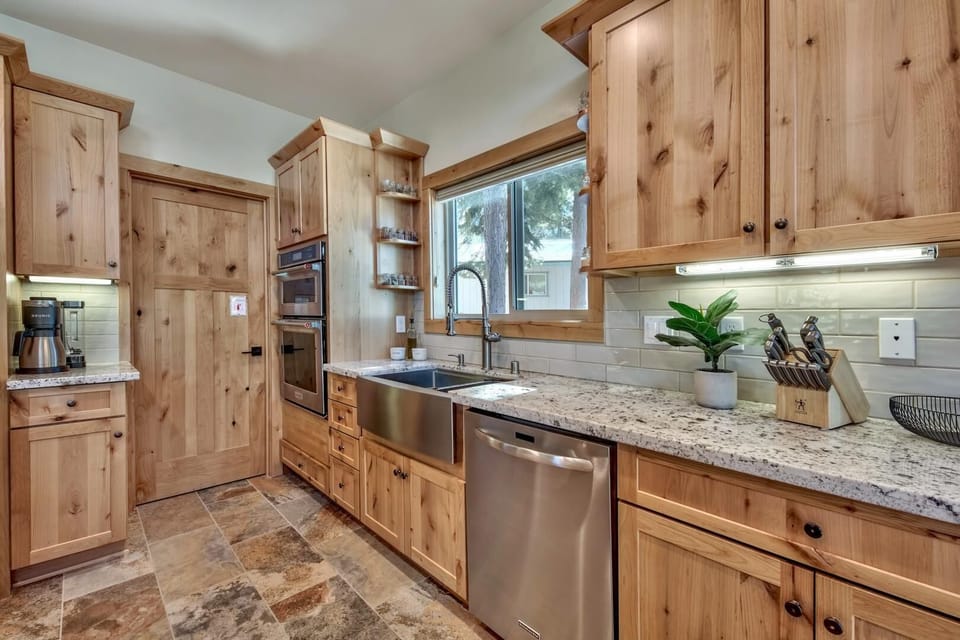 Cook in your fully-equipped kitchen featuring warm wood cabinetry, granite countertops, and stainless steel appliances for memorable home-cooked meals.
