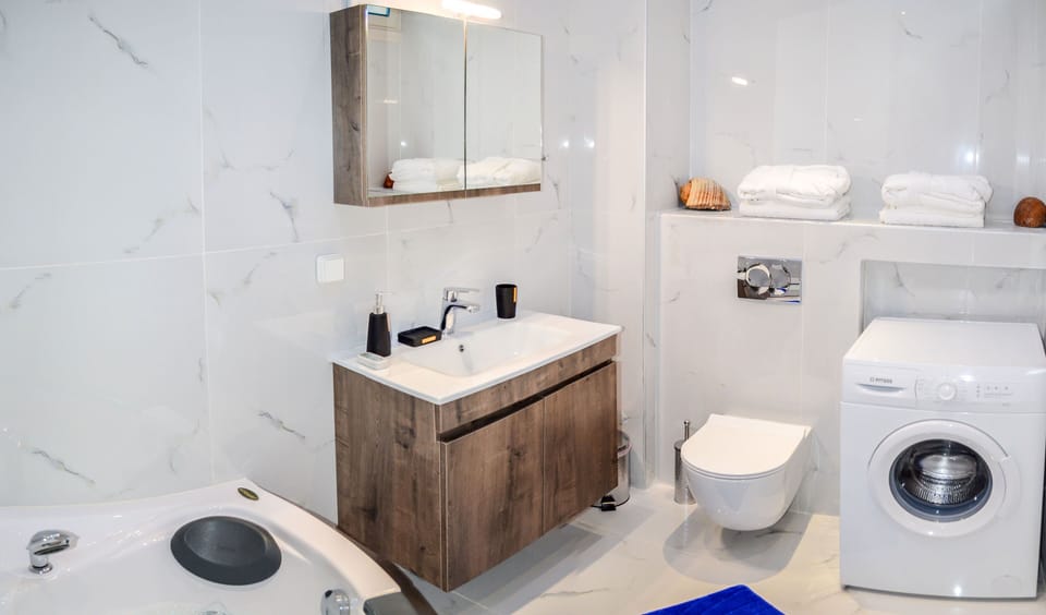 A modern bathroom with washing machine and jacuzzi!!