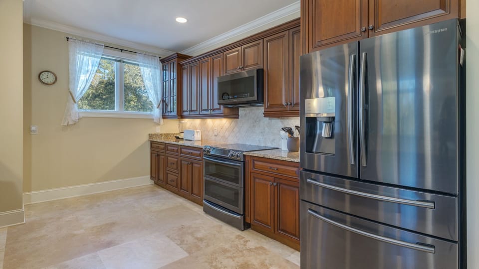 Rich wood cabinetry, granite countertops, and stainless steel appliances create a polished yet welcoming feel.