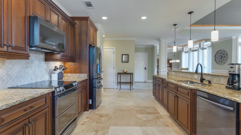 The long layout provides plenty of prep space, while the oversized island with sink keeps the cook connected to the living and dining areas beyond.
