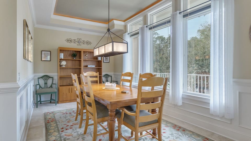 Tall windows line the wall, filling the room with natural light and offering tranquil views of the surrounding trees.