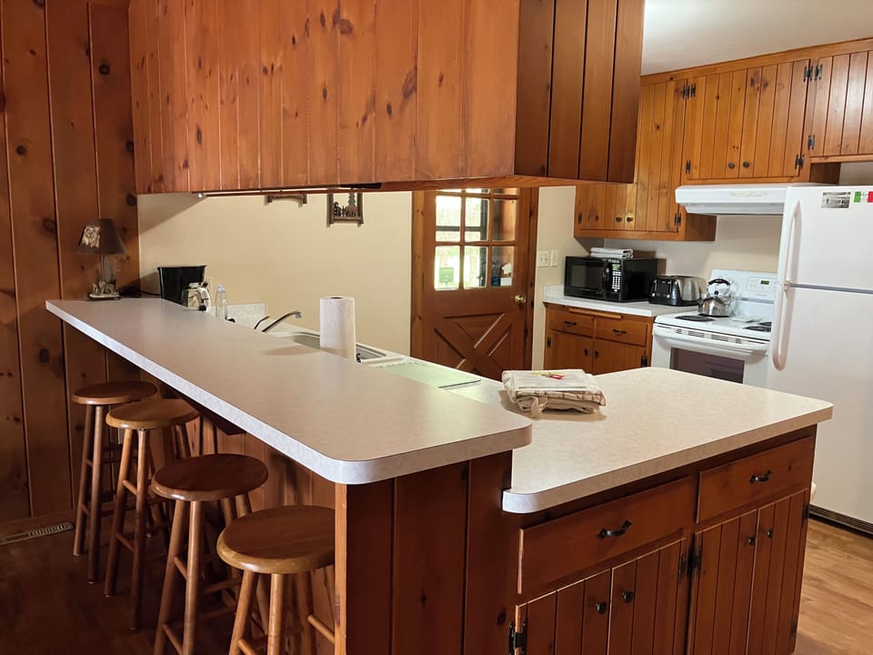 4 stool breakfast bar. Dishes, glassware, utensils.  Micro/Dishwasher. 