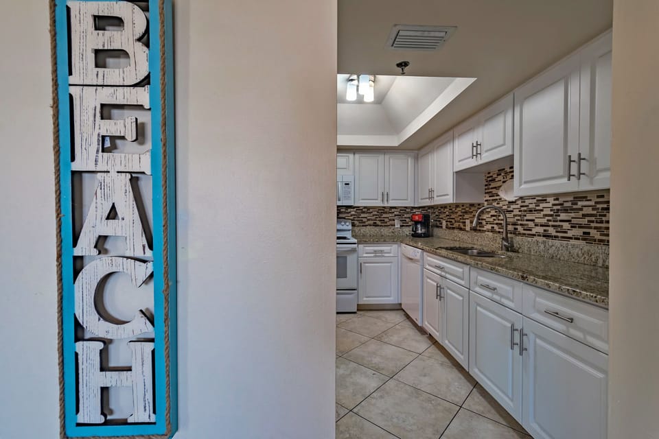 Kitchen boasts granite and lots of kitchen ware.