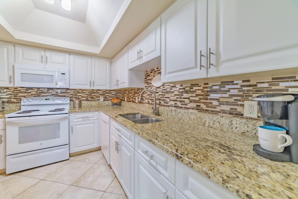 The kitchen is well-stocked with utensils, plates, and cookware.
