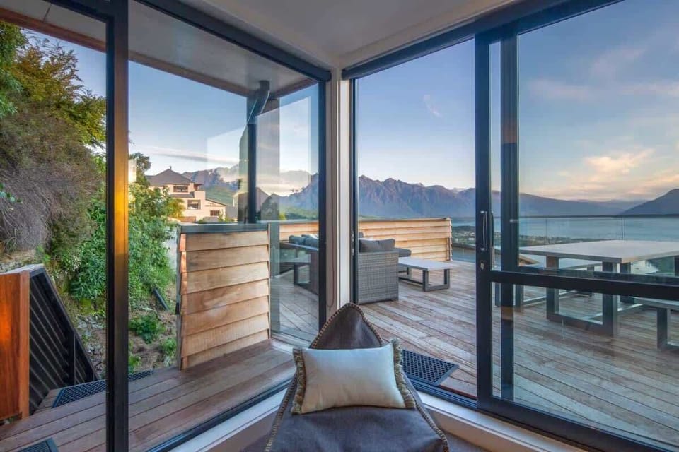 Contemporary Living Area with Lake Views – Relax in this modern living room featuring plush seating, air conditioning for comfort, and large windows offering stunning views of Lake Wakatipu, creating the perfect blend of style and serenity.