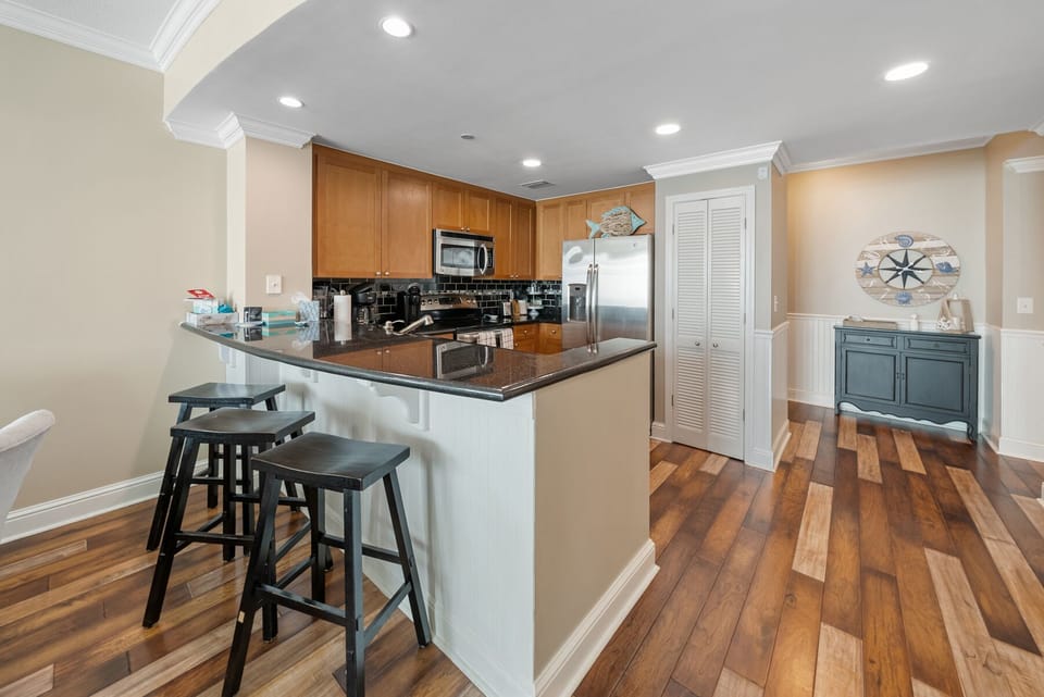 Gather around the spacious kitchen island where granite counters and warm wood floors create the perfect spot for your morning coffee or evening conversations.