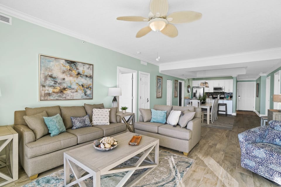 Relax in this spacious living area where soft mint walls and comfortable seating create your perfect coastal retreat.