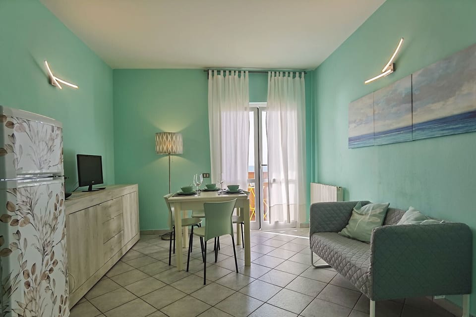 Giannella - Il Germoglio Apartment - The bright living room with restful colors overlooks the balcony overlooking the beach