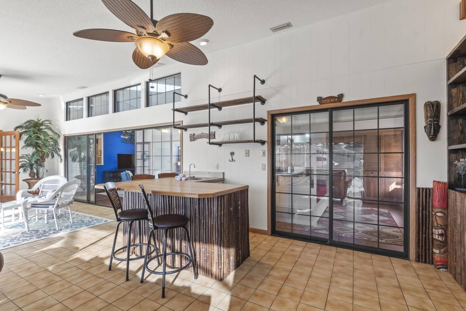 Ample seating area with views of the pool and canal, featuring patio doors that open directly to the pool deck and a Smart TV for entertainment.