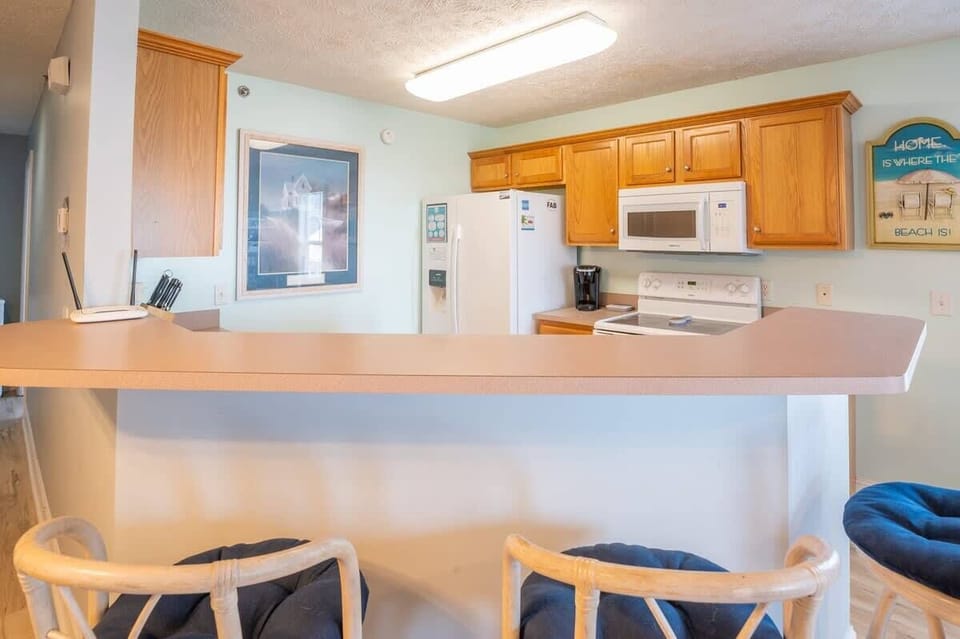 Kitchen with refrigerator, oven and microwave