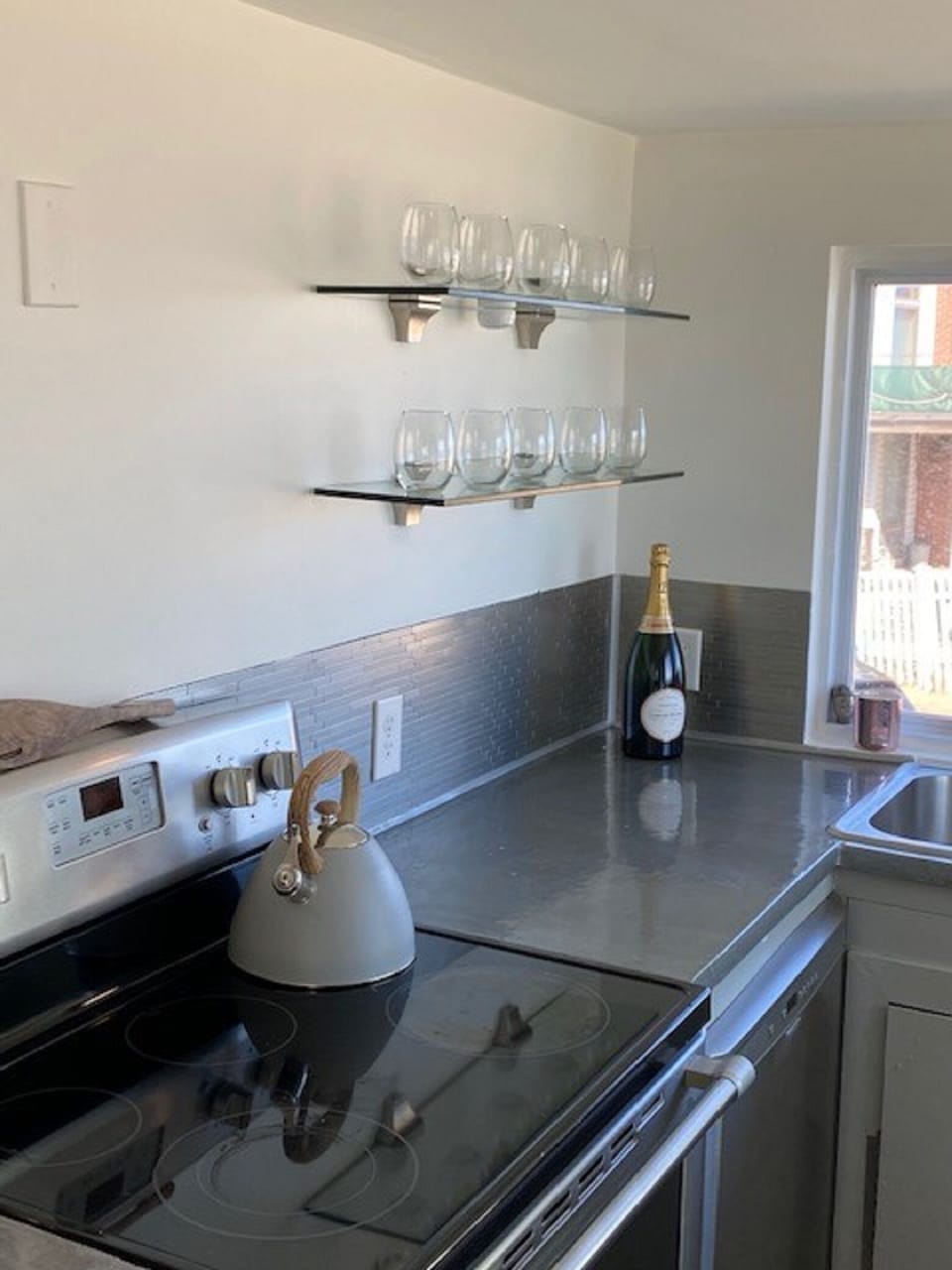 Manageable galley kitchen is fully stocked with plates, cookware & utensils.