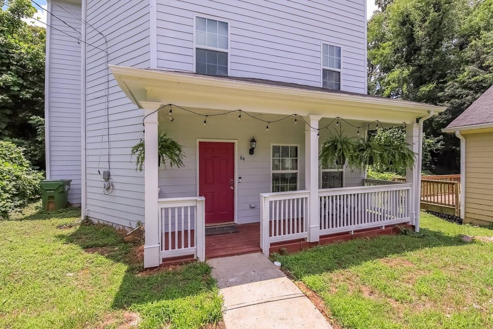 3 story home with covered porch in the front and a deck on the back.