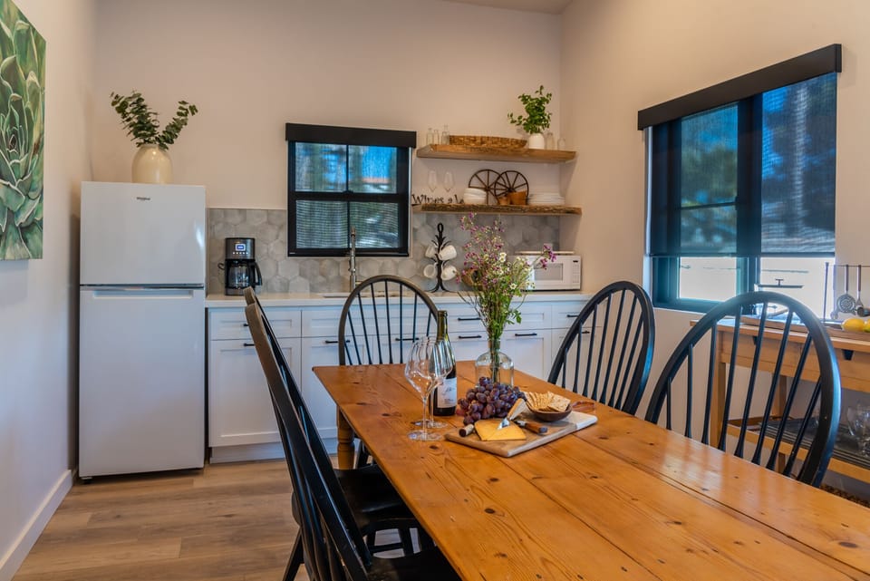 A long dining table sits at the center of this open kitchen with plenty of natural light