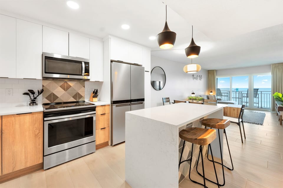 Sleek & modern kitchen with an open layout offers breathtaking ocean views