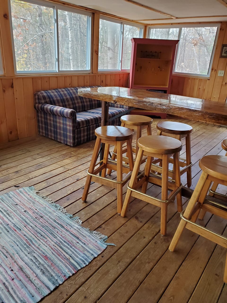Screened-in porch with pub table, stools.