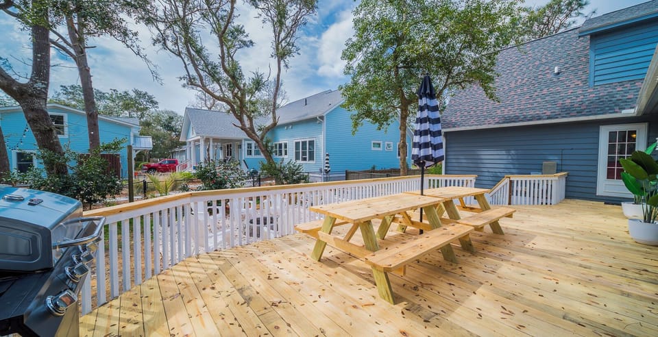 Fenced in backyard with stock tank pool, deck, firepit, and grill.  