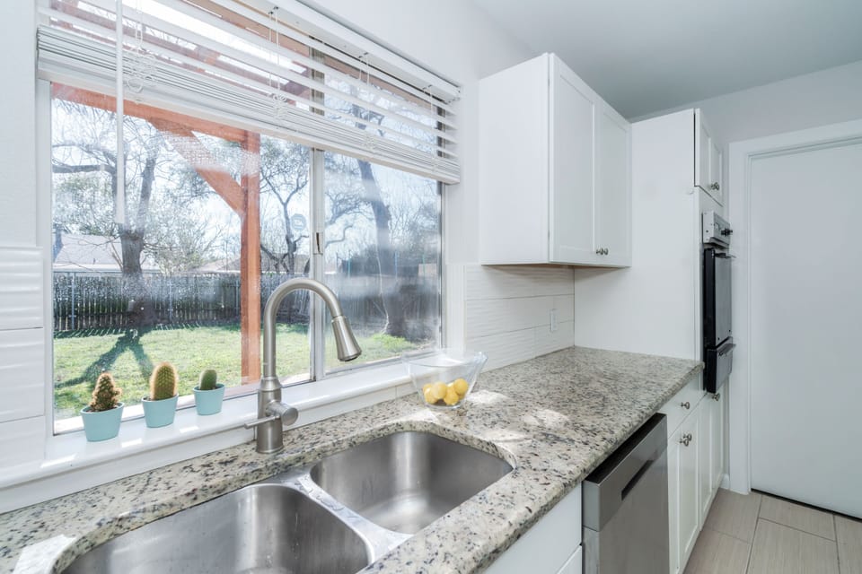 big window with outdoor view over kitchen sink