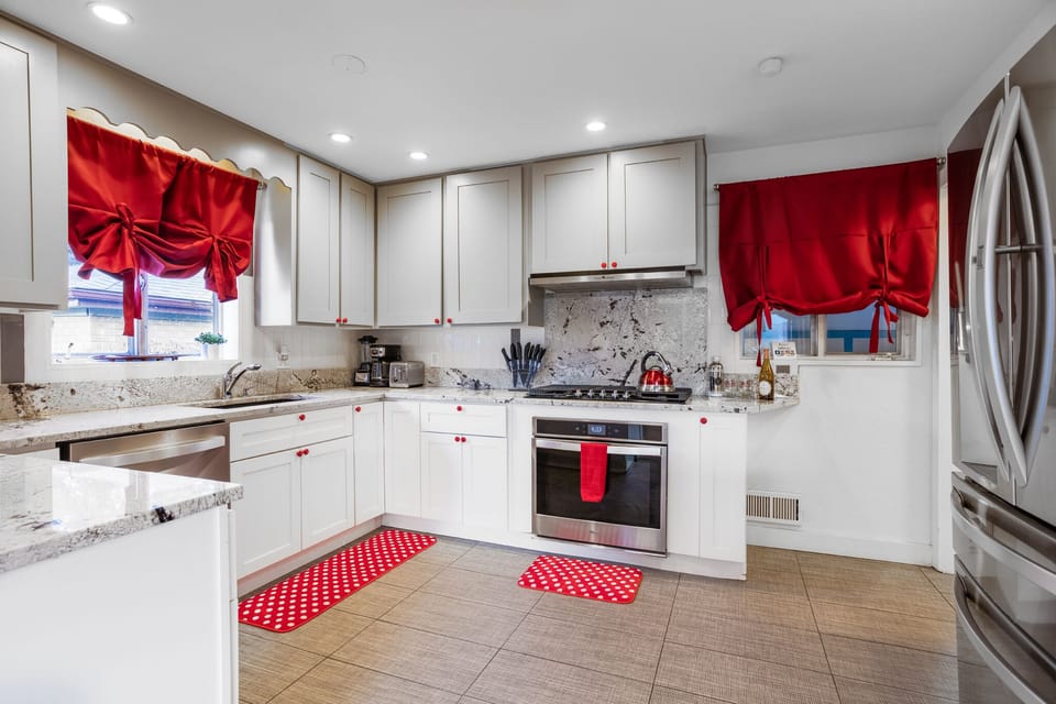 A kitchen designed with striking red and white contrasts, offering a sleek and stylish space for culinary creativity.