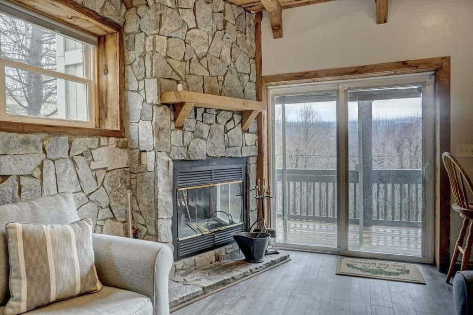 A mountain cabin oasis awaits on the lower floor's cozy family room, featuring stone and wood accents, and an intimate indoor fireplace for your relaxation.