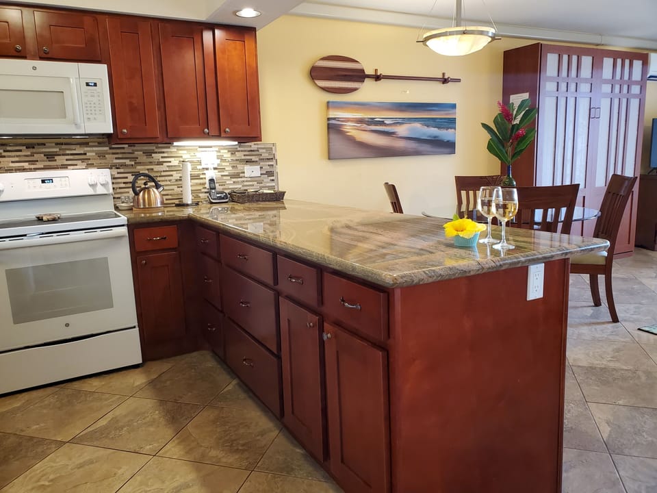 Counter-height bar in gorgeous granite welcomes you to pull up a chair and chat.