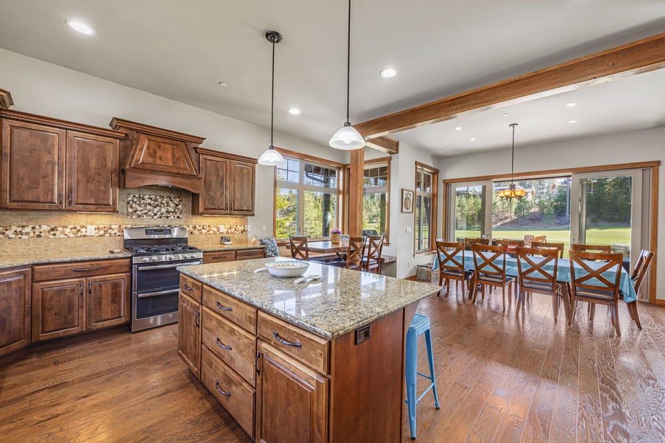 Open kitchen and dining combo with warm wood cabinetry and luxe finishes.