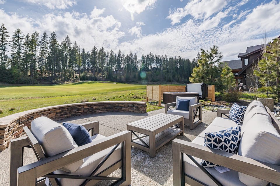 Spacious stone patio with designer lounge seating and sweeping open-sky views.