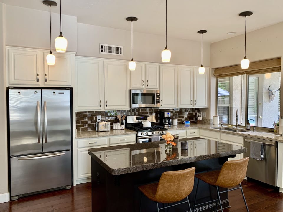 Updated kitchen with island seating and stainless steel appliances and gas range