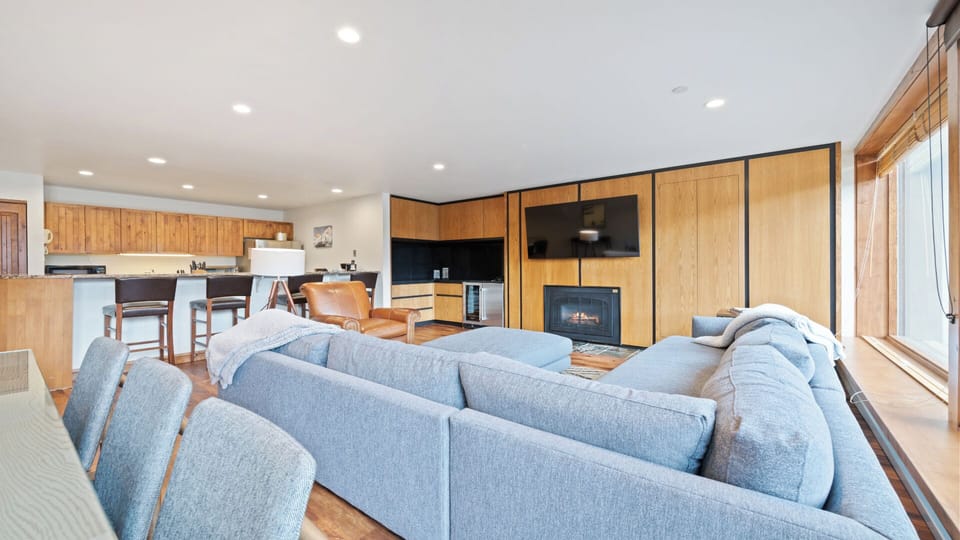 Settle into this bright, open-plan space where modern comforts meet warm wood tones. Relax on plush seating, enjoy cozy evenings by the fireplace, and whip up meals in your fully-equipped kitchen.