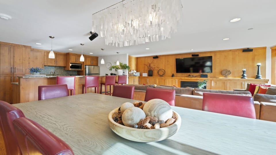 Settle into this bright, open-plan living space where a statement chandelier anchors the room. Rich wood tones, comfortable seating, and a fully equipped kitchen invite you to gather, cook, and unwind in style.