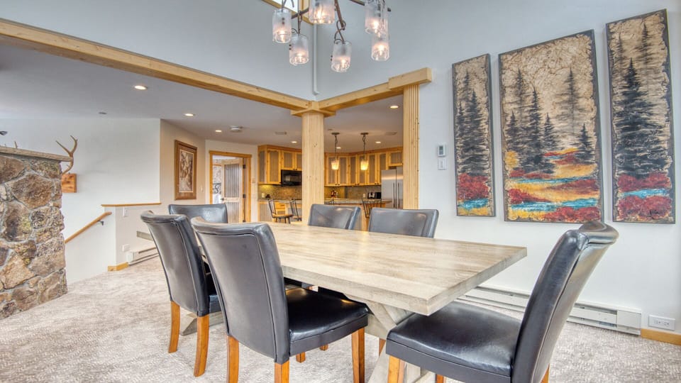 Gather around this spacious dining table with your group, where rustic mountain charm meets modern comfort. The open layout flows seamlessly into your fully-equipped kitchen, perfect for preparing meals together.