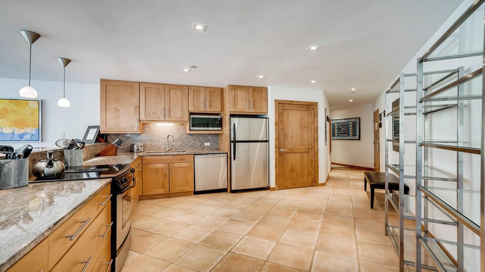 Step into your gourmet kitchen with gleaming stainless steel appliances, warm wood cabinetry, and elegant granite countertops—perfect for preparing delicious meals during your stay.
