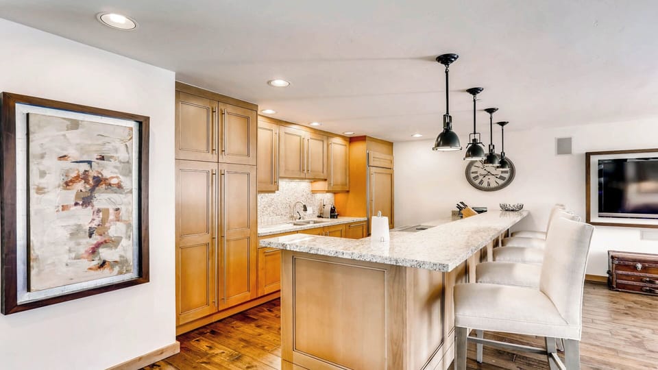 You'll love gathering in this fully-equipped kitchen, featuring gleaming granite countertops, modern pendant lighting, and spacious cabinetry perfect for preparing memorable meals together.