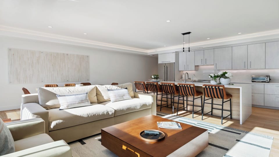 Relax in your open-concept living space where a comfy sofa, chef's kitchen, and island seating invite you to unwind, entertain, and feel completely at home.