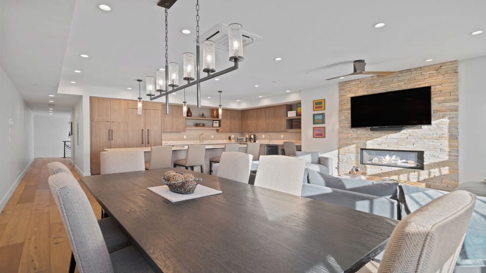 Gather around this spacious dining table where your group can share meals and stories. A modern fireplace and open kitchen complete your home-away-from-home.