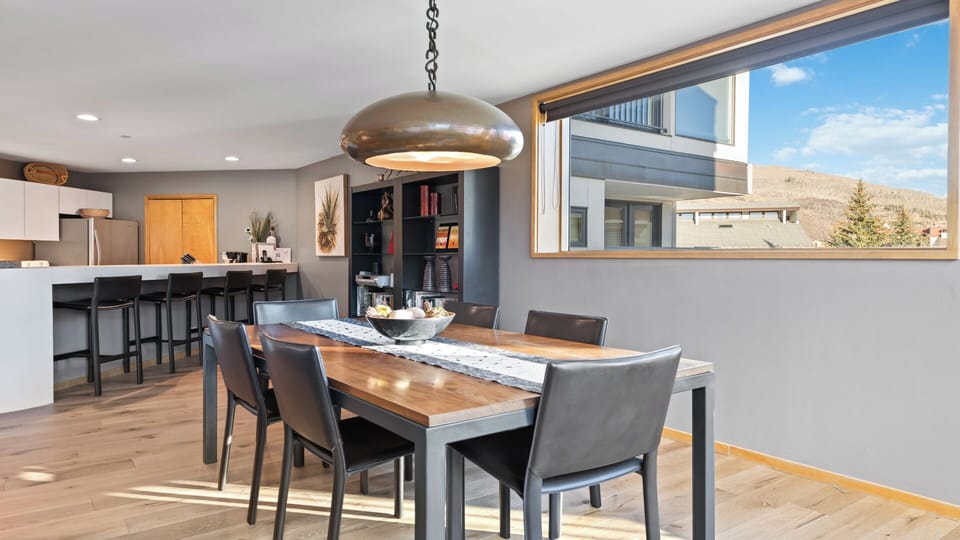 Gather around this stunning dining table with mountain views through expansive windows, where meals become memorable moments in your mountain retreat.