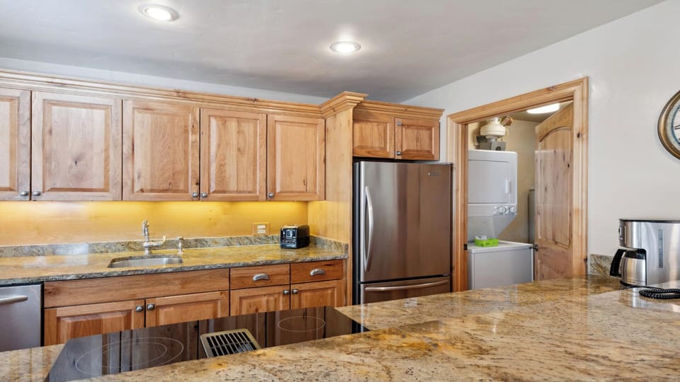 A well-appointed kitchen with granite counters, natural wood cabinetry, and modern stainless appliances—plus your own washer and dryer for ultimate convenience during your stay.