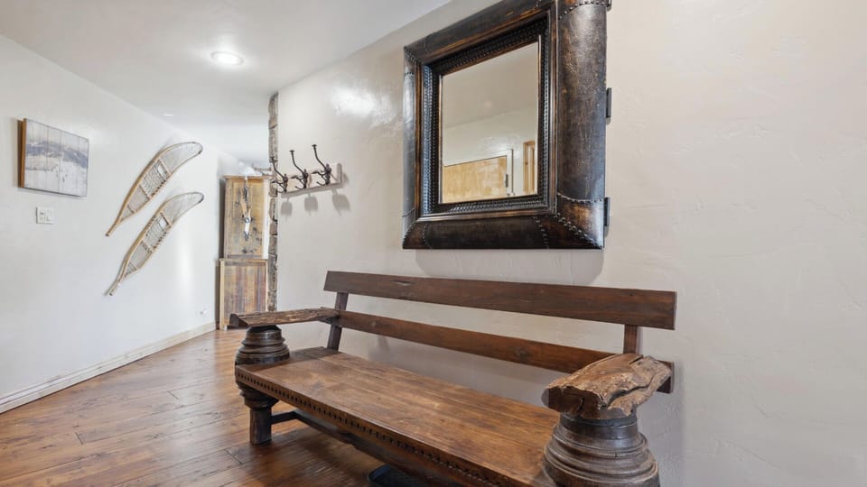 Step into your welcoming entryway, where rustic wood accents and vintage snowshoes create a cozy mountain retreat feel. This charming mudroom offers plenty of hooks for your gear after a day of adventure.
