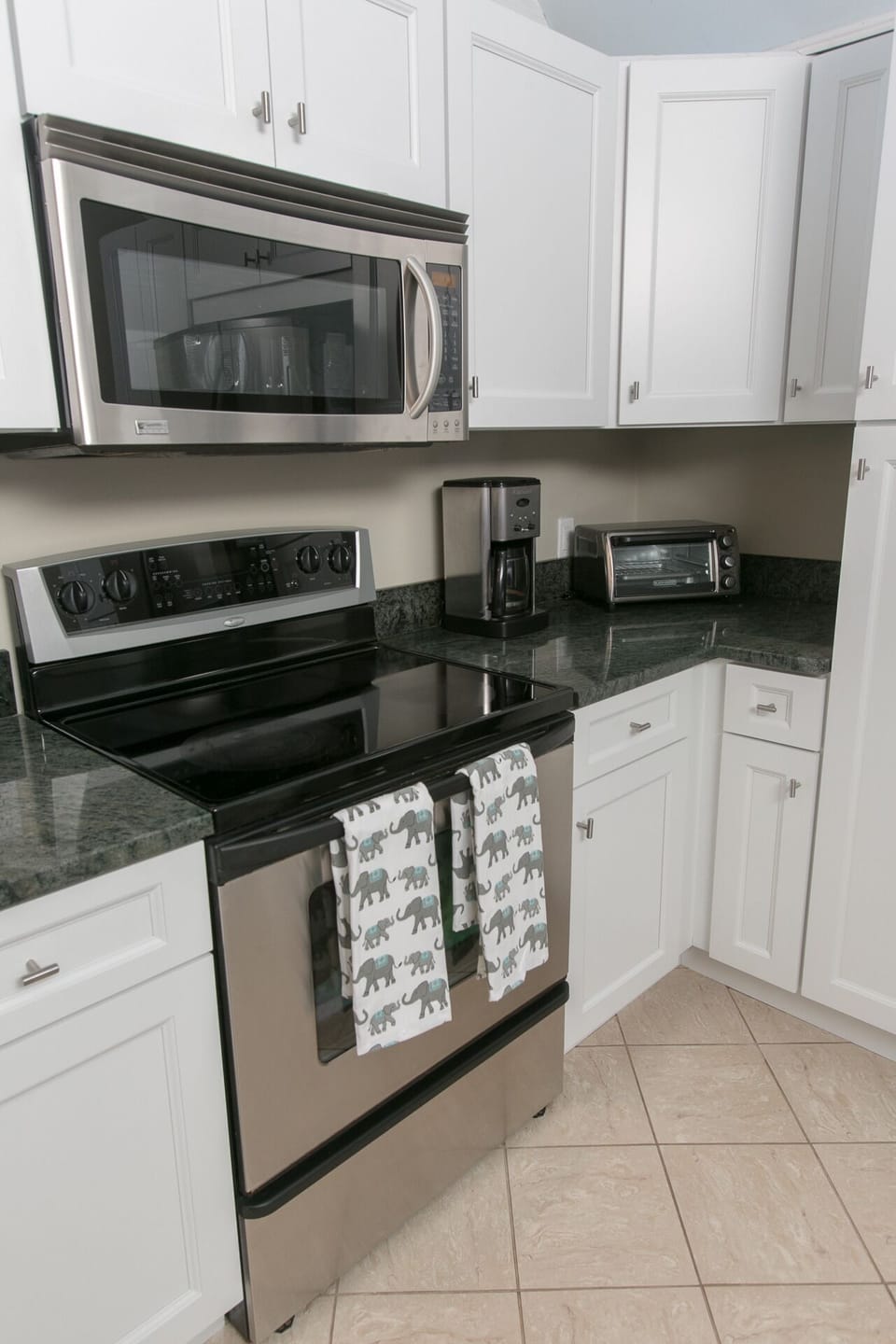 Kitchen with electric cooktop, microwave, toaster, coffee maker.
