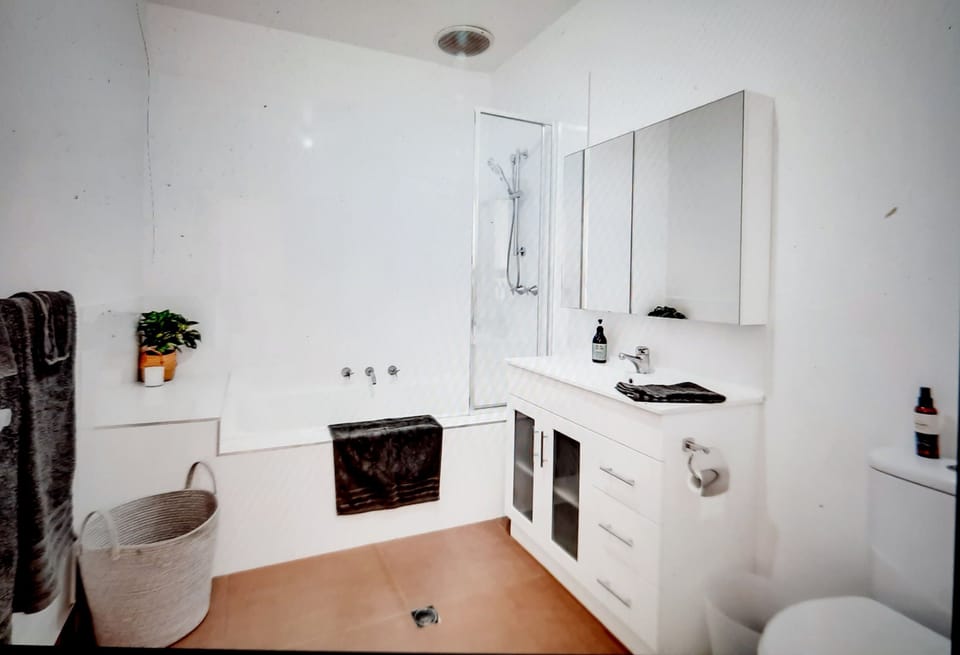 Family bathroom with bath, shower over bath, toilet.