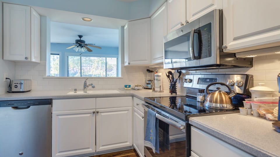 This bright, updated kitchen features crisp white cabinetry, stainless steel appliances, and clean subway tile accents.