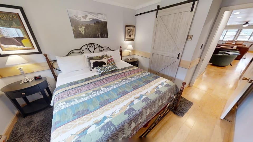 Sink into crisp linens and rustic charm as you unwind in this cozy bedroom, complete with a sliding barn door and mountain art that sets the scene for your relaxing getaway.