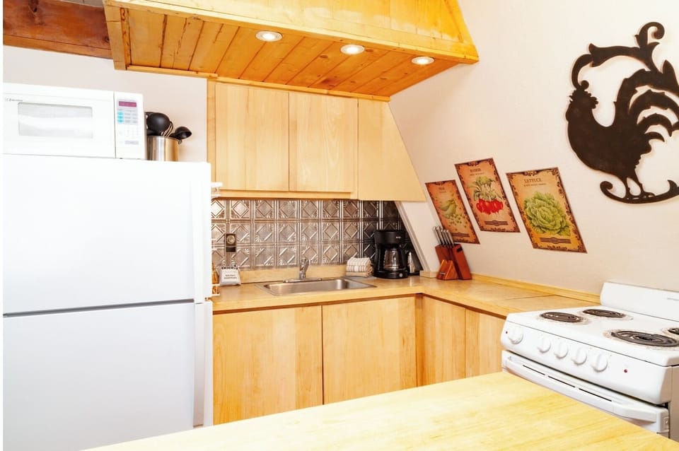 Step into your fully equipped kitchen, complete with stove, fridge, microwave, and all the essentials to whip up your favorite meals. Warm wood tones and thoughtful touches make cooking here a homey, inviting experience.
