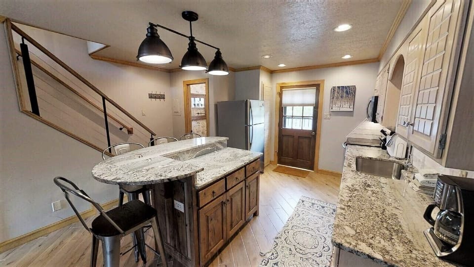 Your fully-equipped kitchen features granite countertops, stainless appliances, and a breakfast bar with seating—perfect for preparing meals and gathering with loved ones.