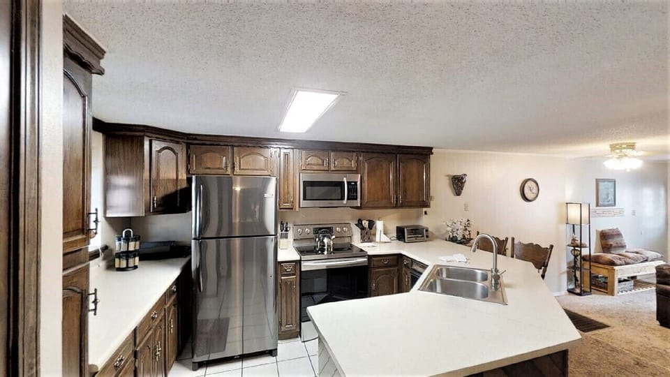 Your fully equipped kitchen awaits with stainless steel appliances, ample counter space, and rich wood cabinetry—perfect for preparing home-cooked meals during your stay.