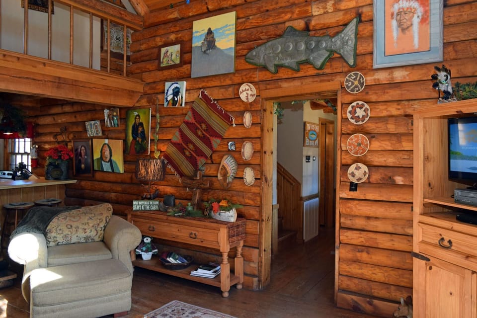 Step into your cozy cabin retreat where rustic charm meets artistic character. Warm wood walls showcase Native American art and cultural treasures, creating an inviting space perfect for unwinding after your adventures.