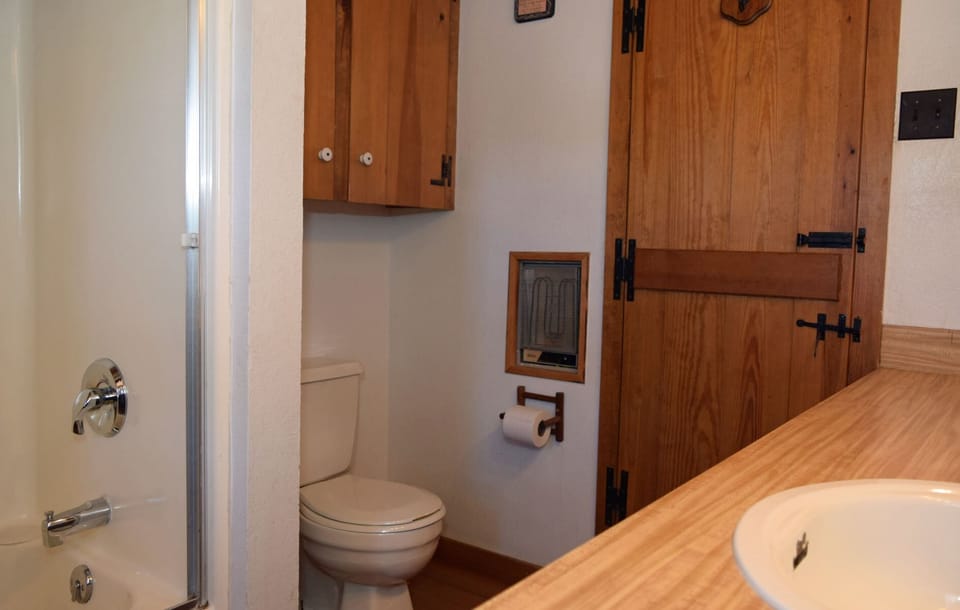 Step into your private bathroom with warm wood details and thoughtful touches. A vintage-style speaker and cozy heater ensure comfort during your stay.